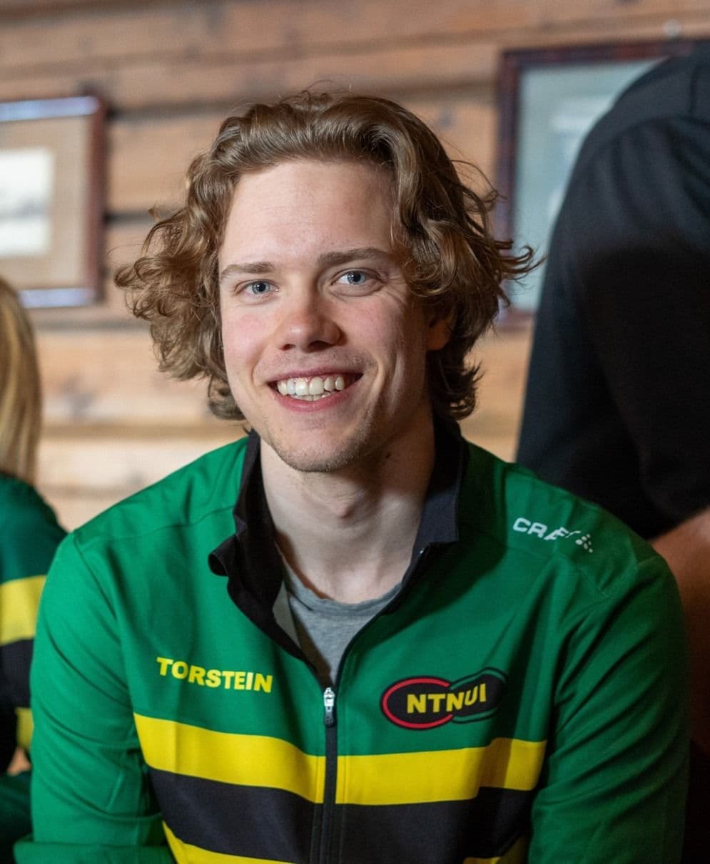 Portrett av en smilende ung mann i grønn NTNUI-jakke med navnet Torstein.