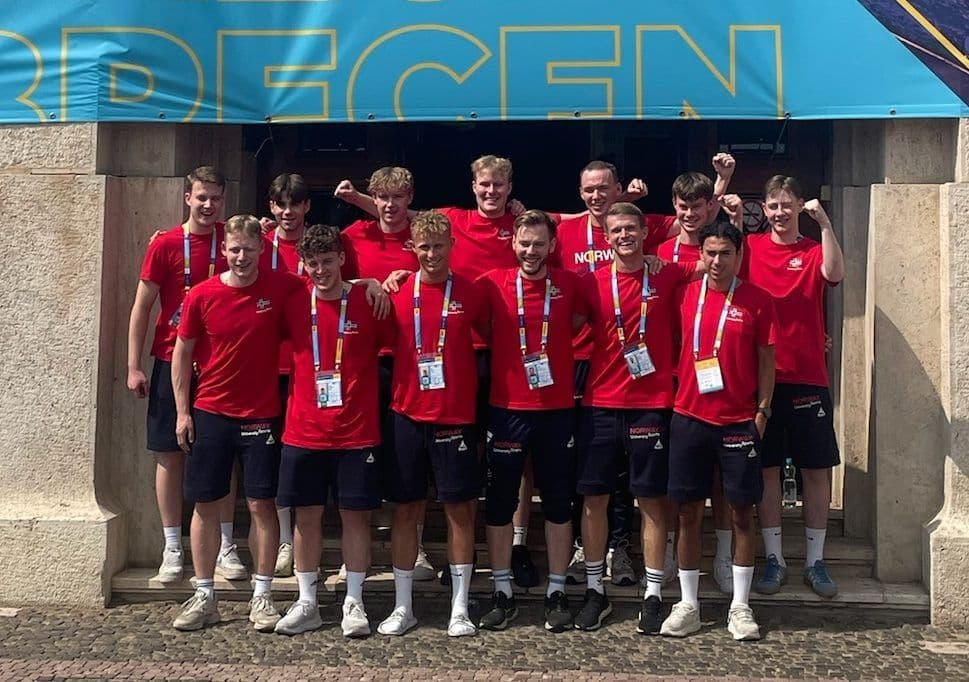 En lengdehopper lander i sandgropa med armene hevet under FISU-lekene i Chengdu.