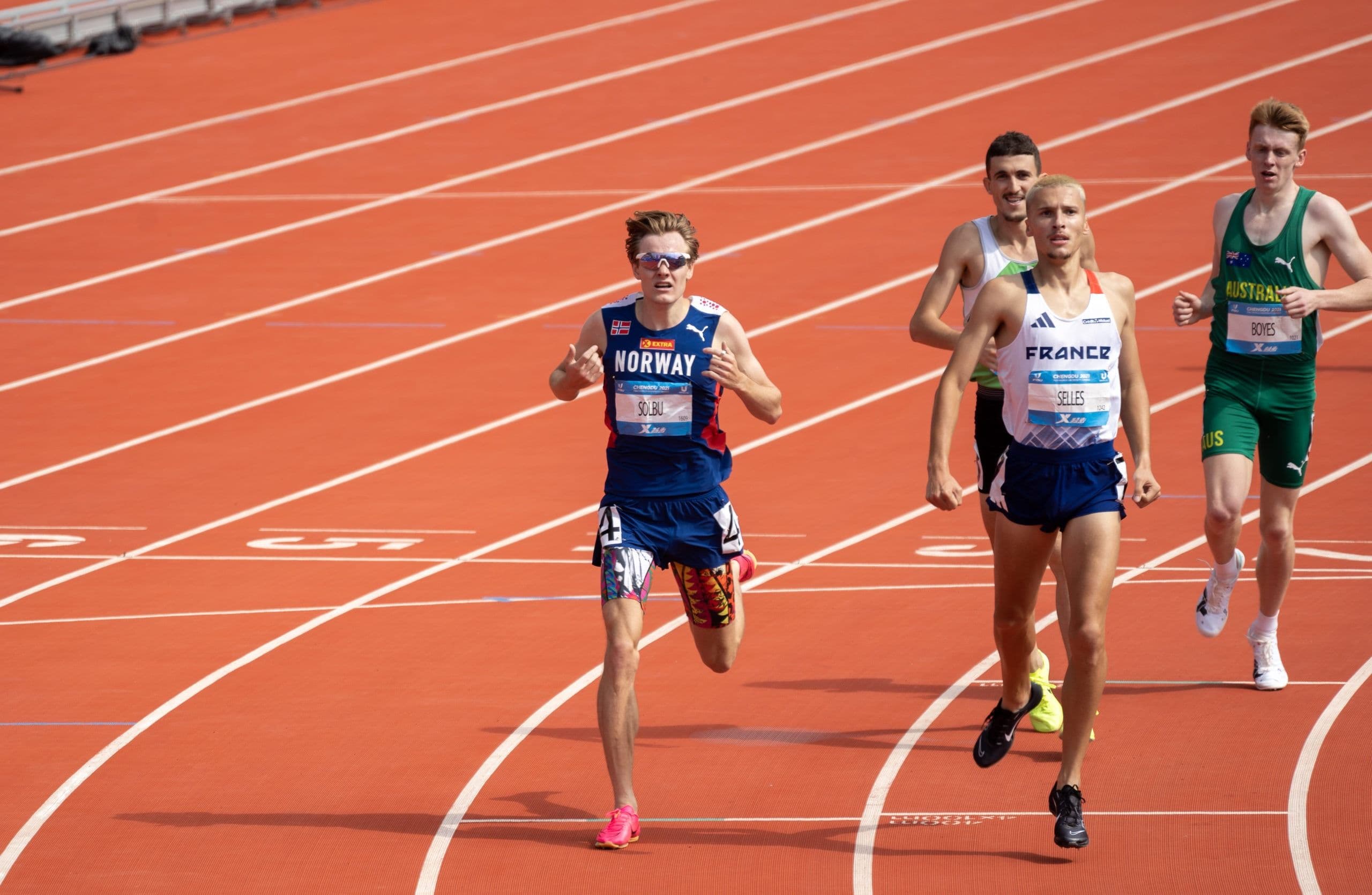 Friidrettsutøvere løper på løpebanen, den fremste med Norway-singlet.