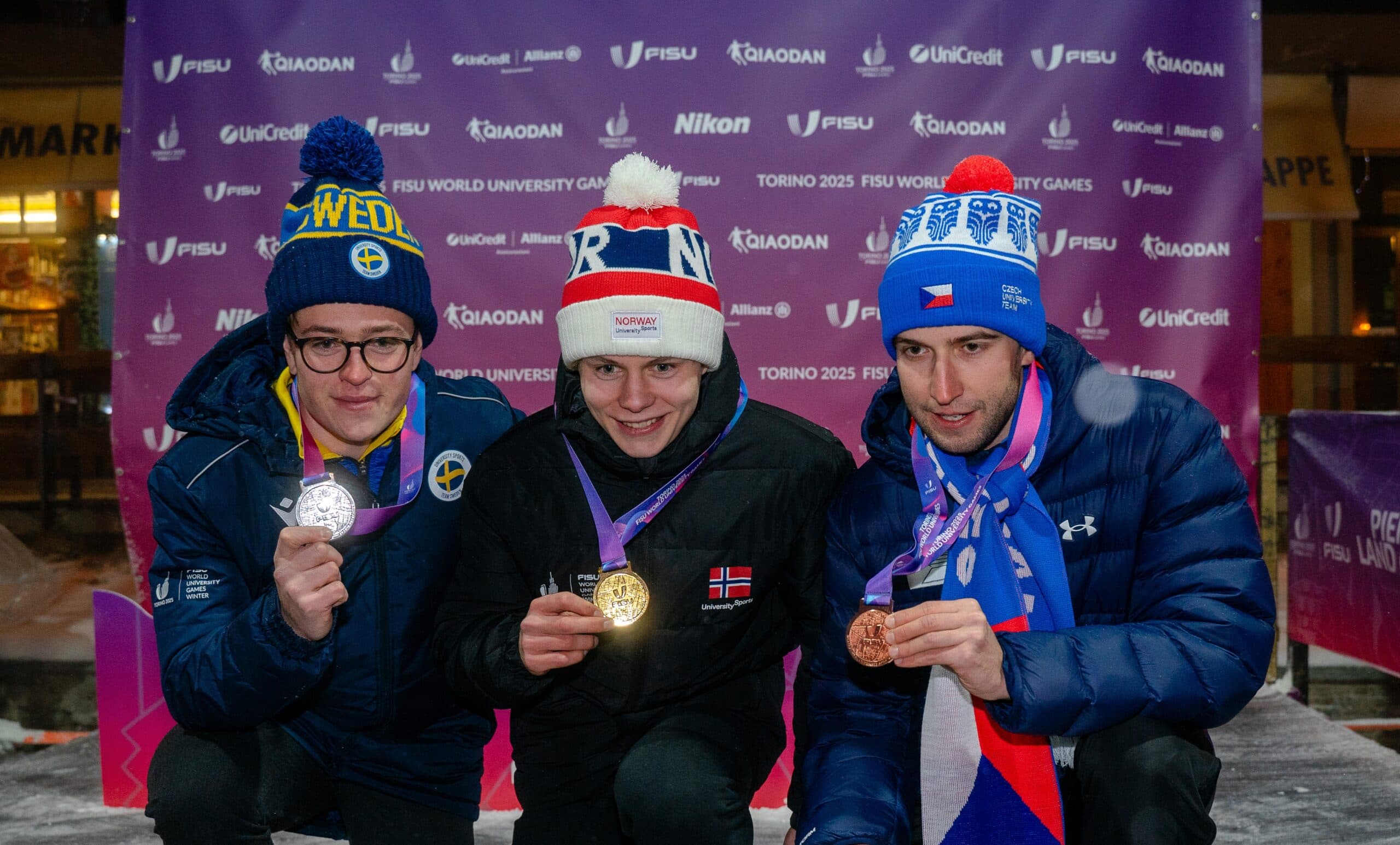 Tre medaljevinnere viser fram medaljene sine under FISU World University Games Torino 2025.