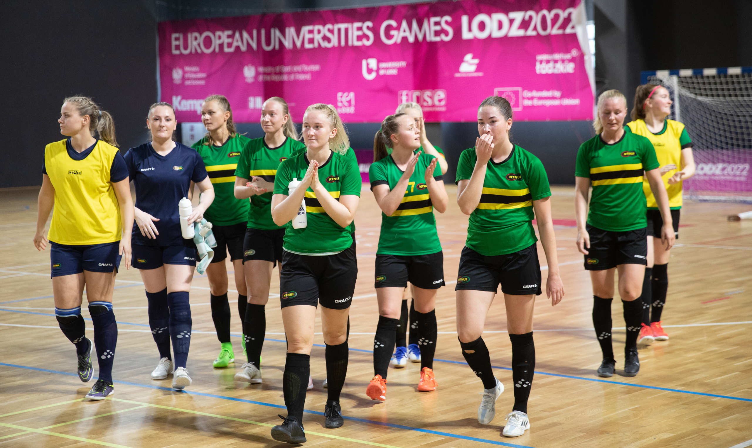 Kvinnelig futsallag i grønne drakter går inn på banen under European Universities Games Lodz 2022.