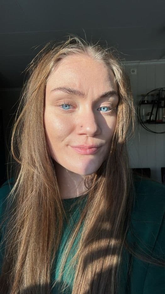 Portrett av en kvinne med langt hår, tatt innendørs i sollys.
