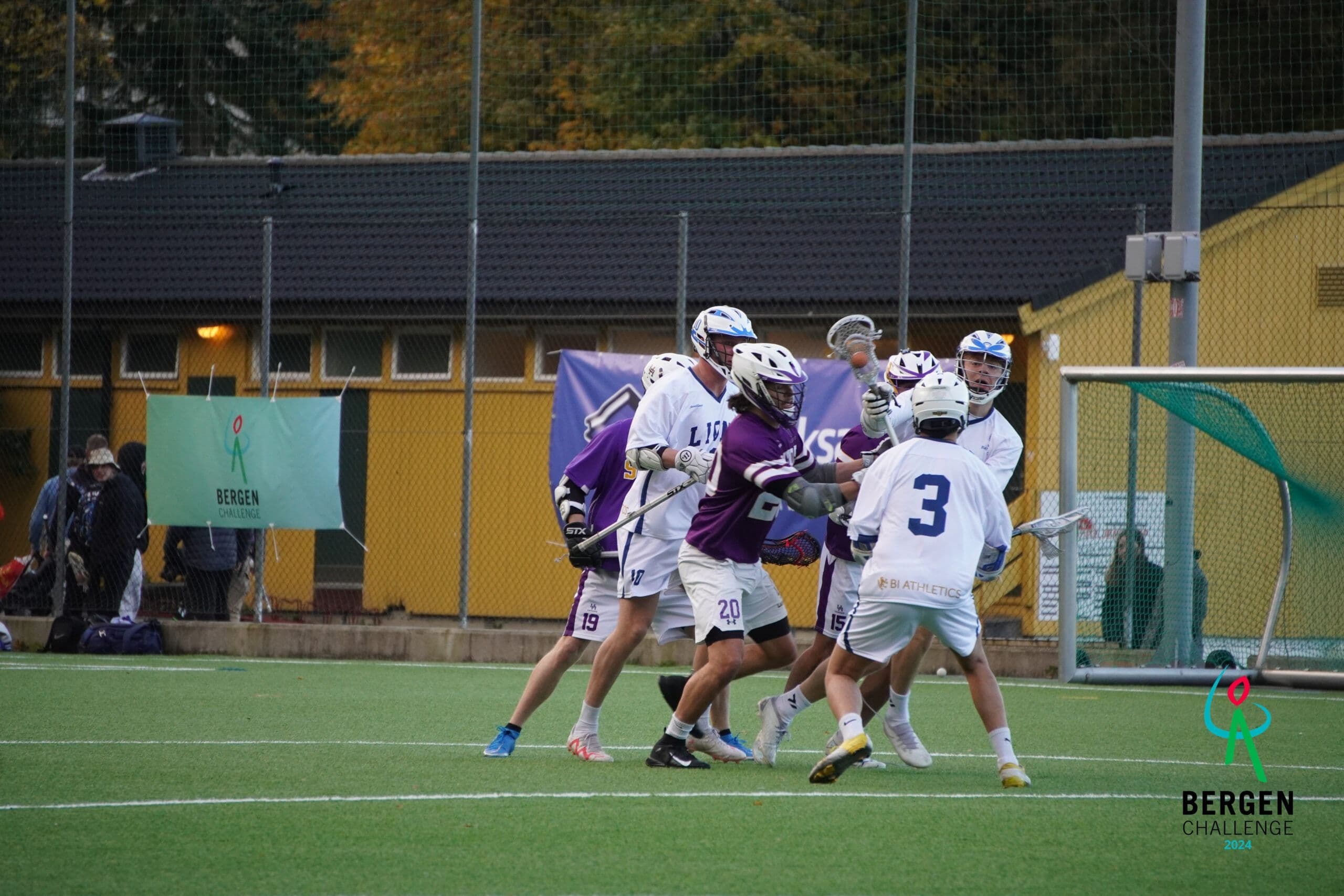 Mannlige lacrossespillere i kamp om ballen på en kunstgressbane under Bergen Challenge.