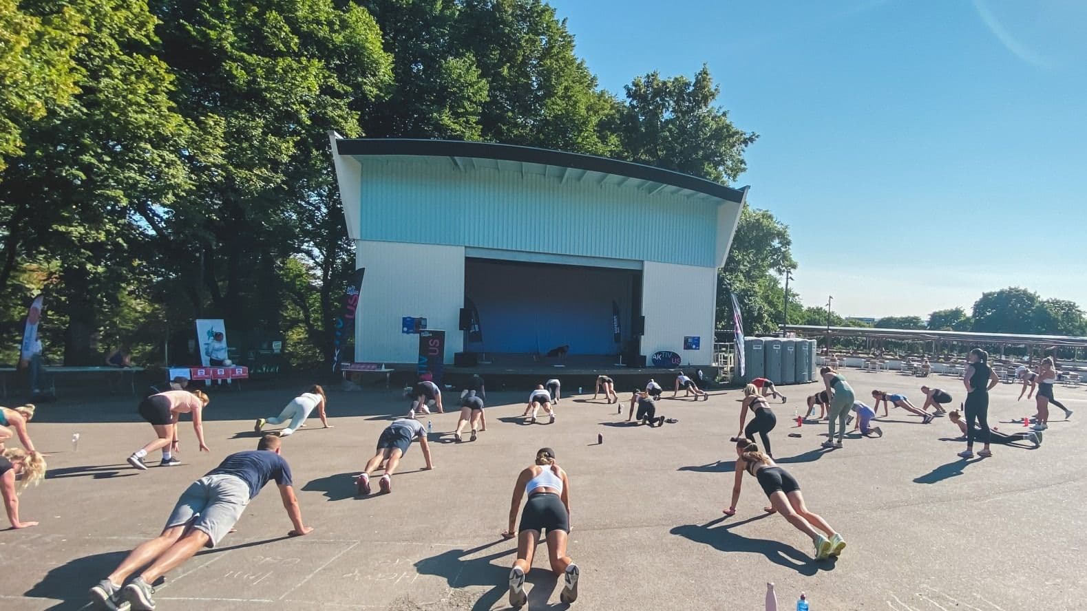 En gruppe studenter trener utendørs foran en musikkpaviljong under Aktiv Campus i Oslo.